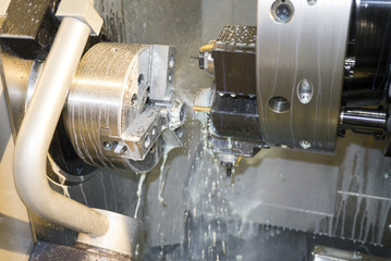 Processing detail on CNC lathe with coolant. Work zone of CNC machine.