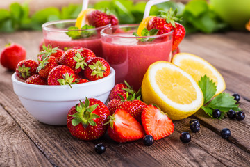 Strawberry on wood background. Strawberry with green leaves.