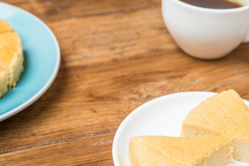 Slice of Plain Cheesecake on white plate on wooden background