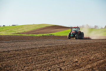 Tractor cultivating field at spring