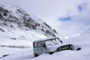 Old russian jeep buried in deep snow in the mountains