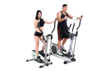 Obraz na płótnie Canvas young woman and man doing exercises on elliptical cross trainer