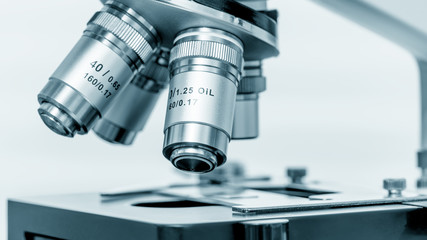 Microscope and test tubes in laboratory, Blue toned image