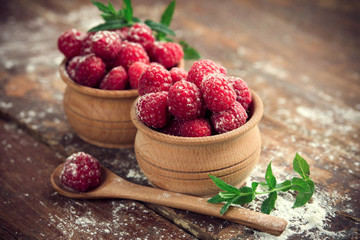 Ripe sweet raspberries on wooden background
