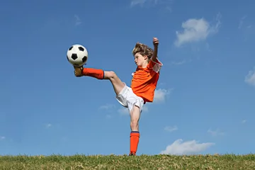 Tuinposter kid playing football or soccer © godfer
