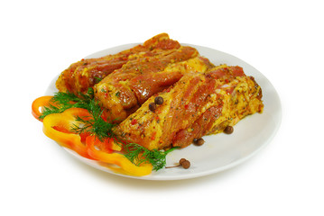 Raw meat. Pork  slices with sause and fresh pepper in a Dish Isolated Against White Background