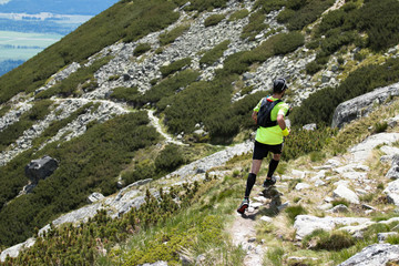 man in compress socks running outdoors on the high mountain trail 
