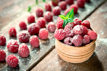 Ripe sweet raspberries on wooden background