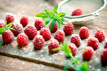 Ripe sweet raspberries on wooden background