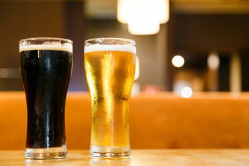 Two glasses of fresh cold beer. A glass  dark , the other light.
