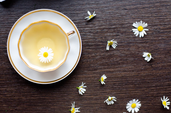 Herbal Camomile Tea In A Porcelain Cup On A Dark Wooden Background