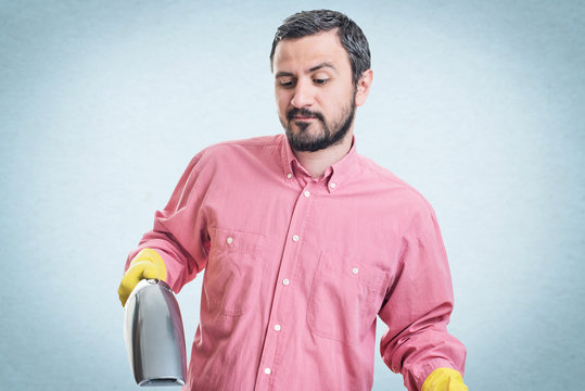 Smiling young man with handheld vacuum cleaner