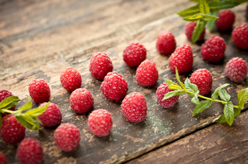 Ripe sweet raspberries on wooden background