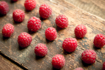 Ripe sweet raspberries on wooden background
