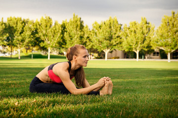 Pretty woman doing yoga exercises in the park