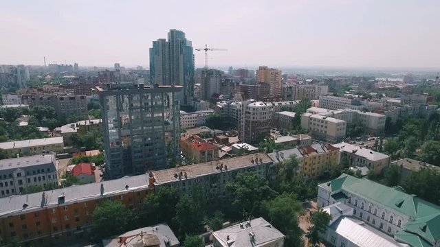 amera is flying near modern building with mirror windows, over park