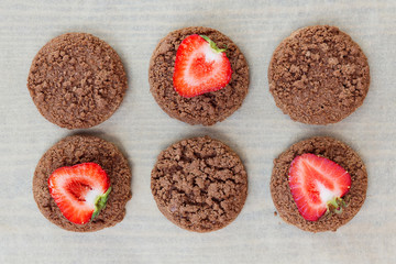 strawberry fruits and cookies at the bottom on wooden background with copy space. View from above.