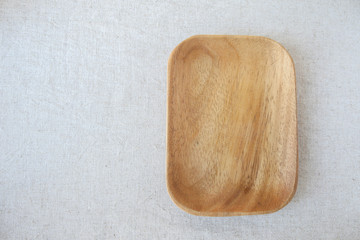 Empty wooden plate on linen table background for food display montage