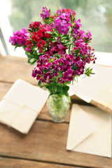 Beautiful meadow flowers bouquet of flower and envelopes in room