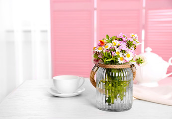 Meadow bouquet with cup on table