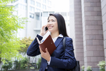 Fototapeta premium 電話をする若い女性 屋外ビジネスイメージ
