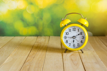 Yellow clock on wood table