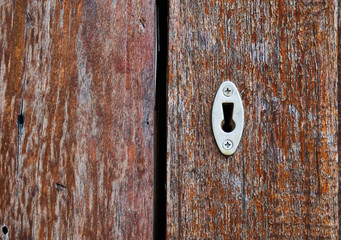 Close up picture of key hole on wooden door