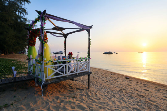 Romantic sunset dinner set up for couple by the beach