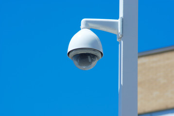 security camera post outside on blue sky 
