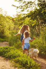 Little sisters walk with the dog