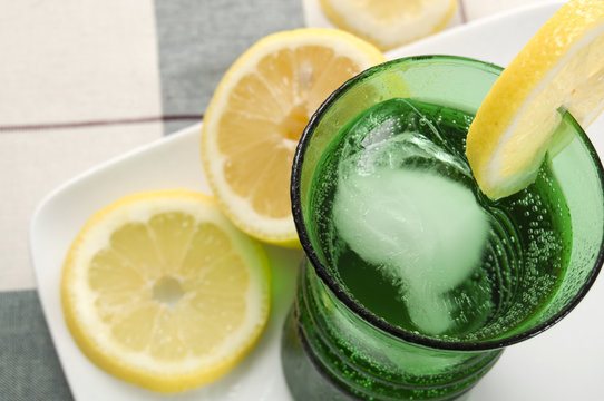 Carbonated Water with Lemon in Green Glass