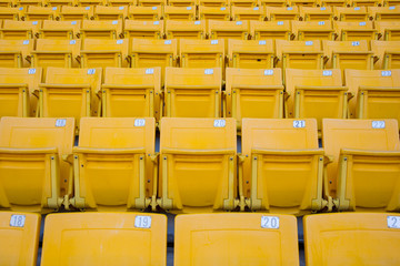 Seating rows in a stadium with weathered chairs