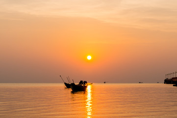 Fototapeta premium silhouette of Small fishing boats on the sea during sunrise