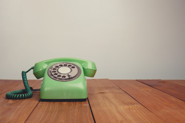 Vintage tone of Retro rotary telephone on wood table