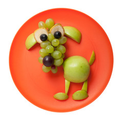 Fototapeta na wymiar Confused dog made of green apple on orange plate