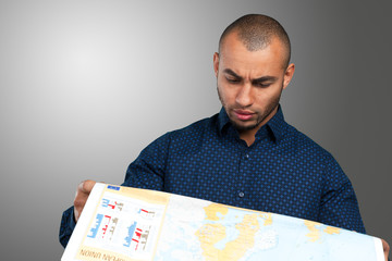 Young mixed race man with map