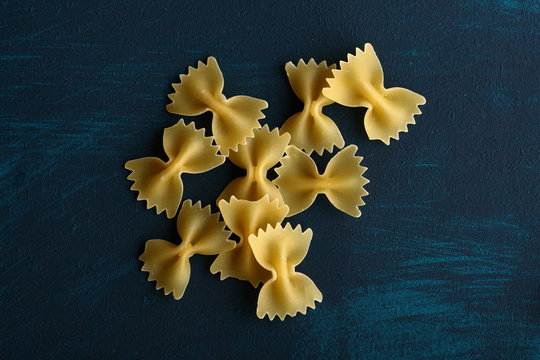 raw farfalloni pasta pn a blue background