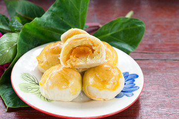 A small sweet chinese pantry cake on plate with green leaf
