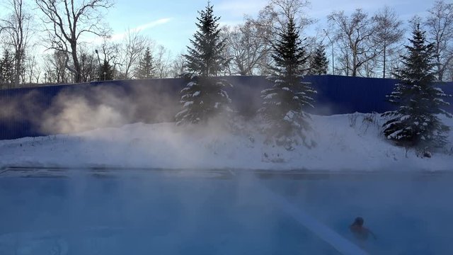 thermal underground hot spring open-air pool water evaporates the moisture and gives off heat frosty winter day