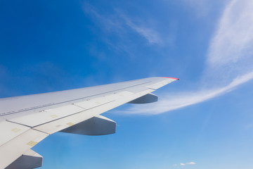 View from airplane window with blue sky and white clouds