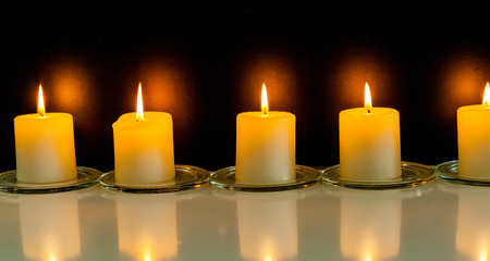 closeup to burning candles in darkness