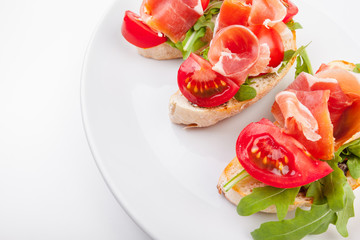Jamon. Slices of Bread with Spanish Serrano Ham Served as Tapas. Cured ham, spanish appetizer. Prosciutto isolated on white background