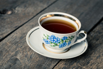 Closeup of cup of tea on vintage wooden background