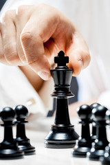 Hand of businessman playing chess