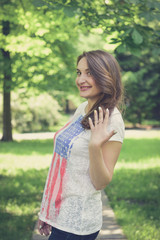 Fototapeta premium Beautiful sexy young hipster girl outdoors.Posh woman with long brunette hair evening makeup wearing jeans and vans sneakers posing outdoors in the city urban style in summer
