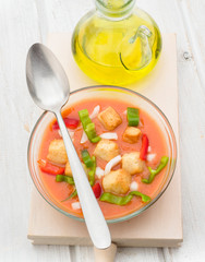 Overhead view spoon vegetables and gazpacho soup round  bowl