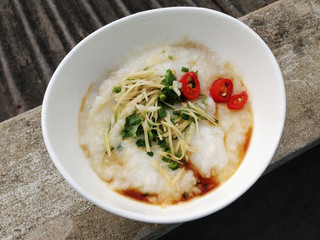 asian food - a bowl of congee with minced pork on grunge background