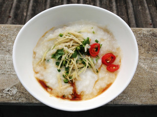 asian food - a bowl of congee with minced pork on grunge background