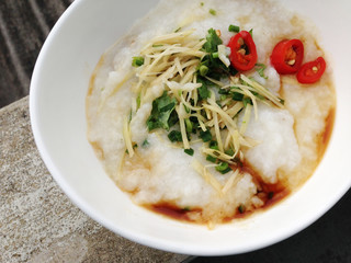 asian food - a bowl of congee with minced pork on grunge background