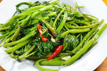 stir fried morning glory on white dish
